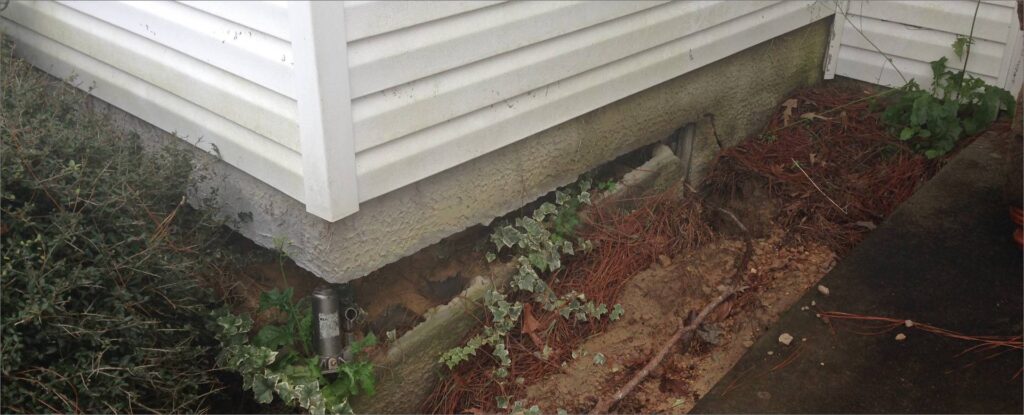 Fondation résidentielle dégagée par excavation pour l’inspection et la réparation d’une fissure.