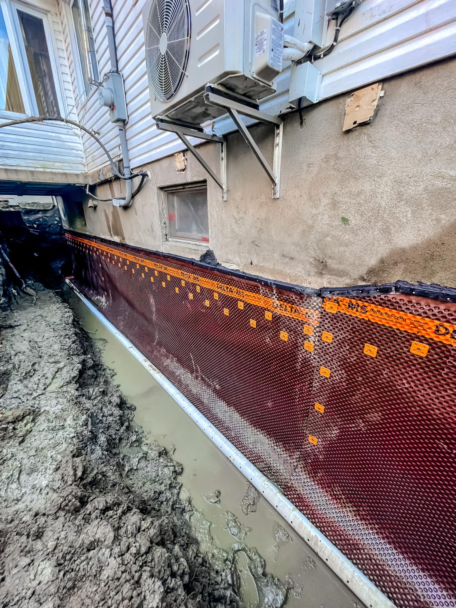 Drainage excavation for building foundation in progress at a construction site.