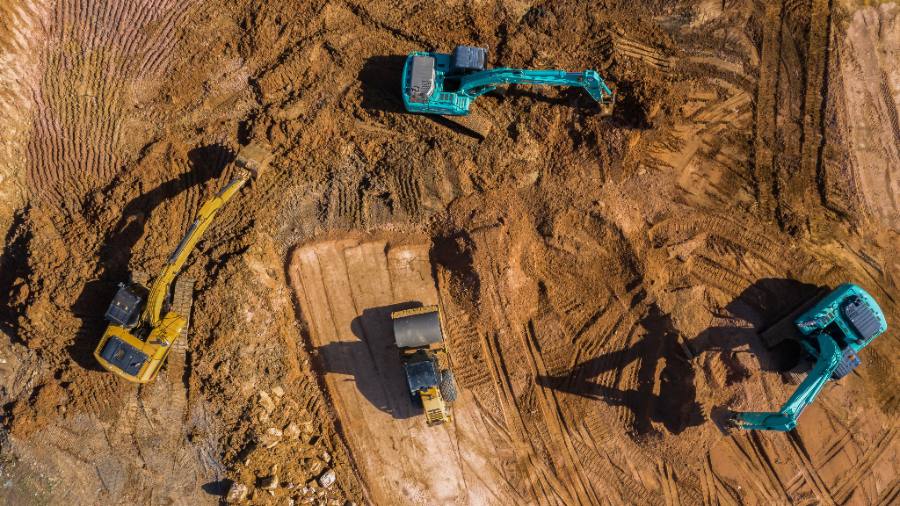 Vue aérienne d’un chantier d’excavation avec plusieurs excavatrices et machinerie lourde en opération.