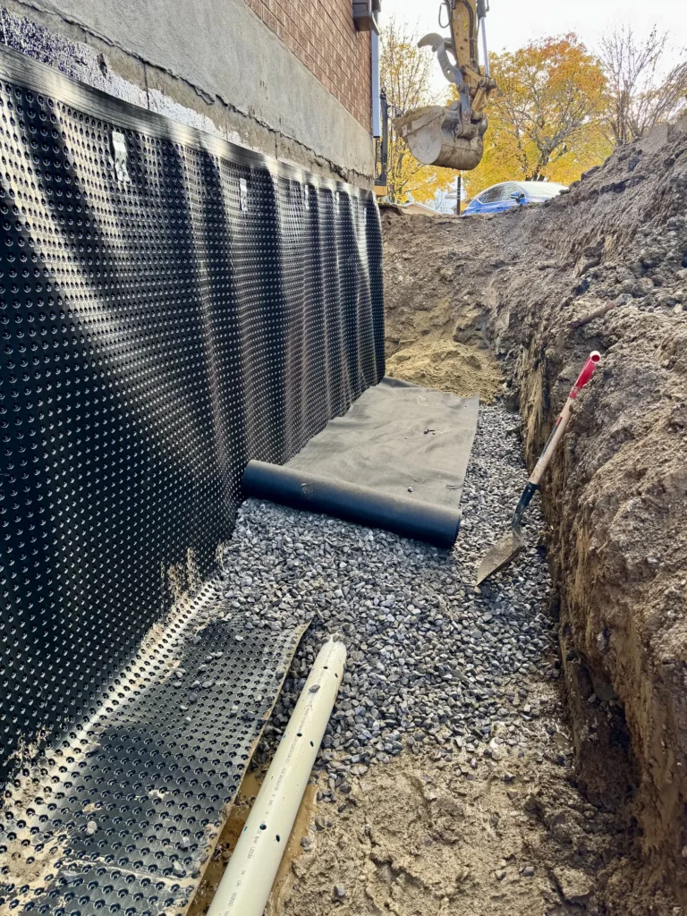 Impermeabilisation de fondation avec membrane drainante alveolee, drain francais et gravier dans tranchee