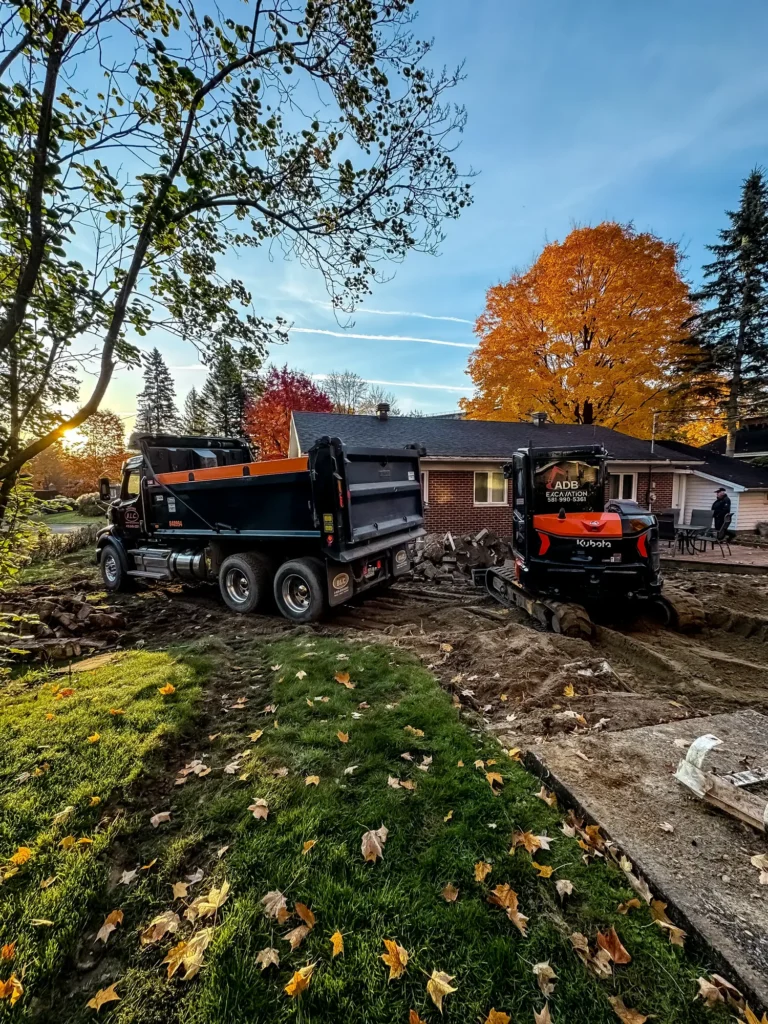 Camion et excavatrice sur un terrain en construction pendant l'automne.